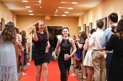 Two girls run down the red carpet at Night to Shine